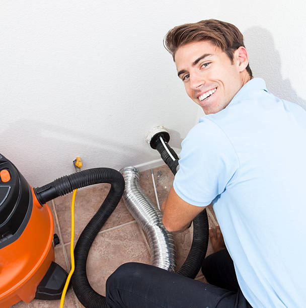 Man cleaning dryer vent in home.